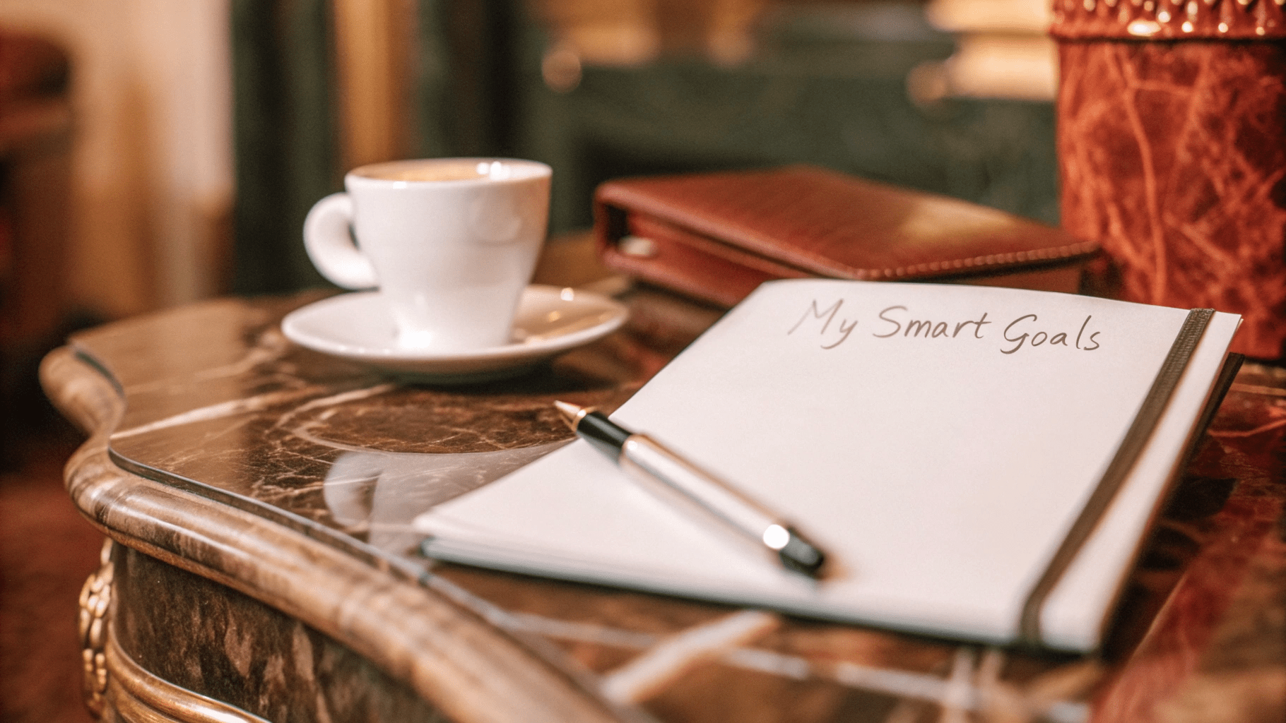 a note on a table next to a cup of coffee and a notepad ready to set smart goals
